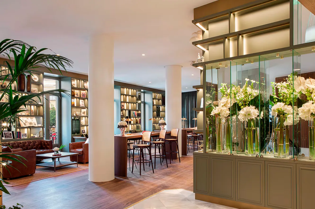 Zona de estar del lobby del hotel Gran Meliá Colón en Sevilla con mobiliario de descanso.