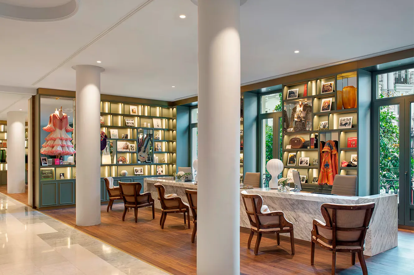 Recepción del hotel Gran Meliá Colón en Sevilla con mostrador y zona de atención al huésped.